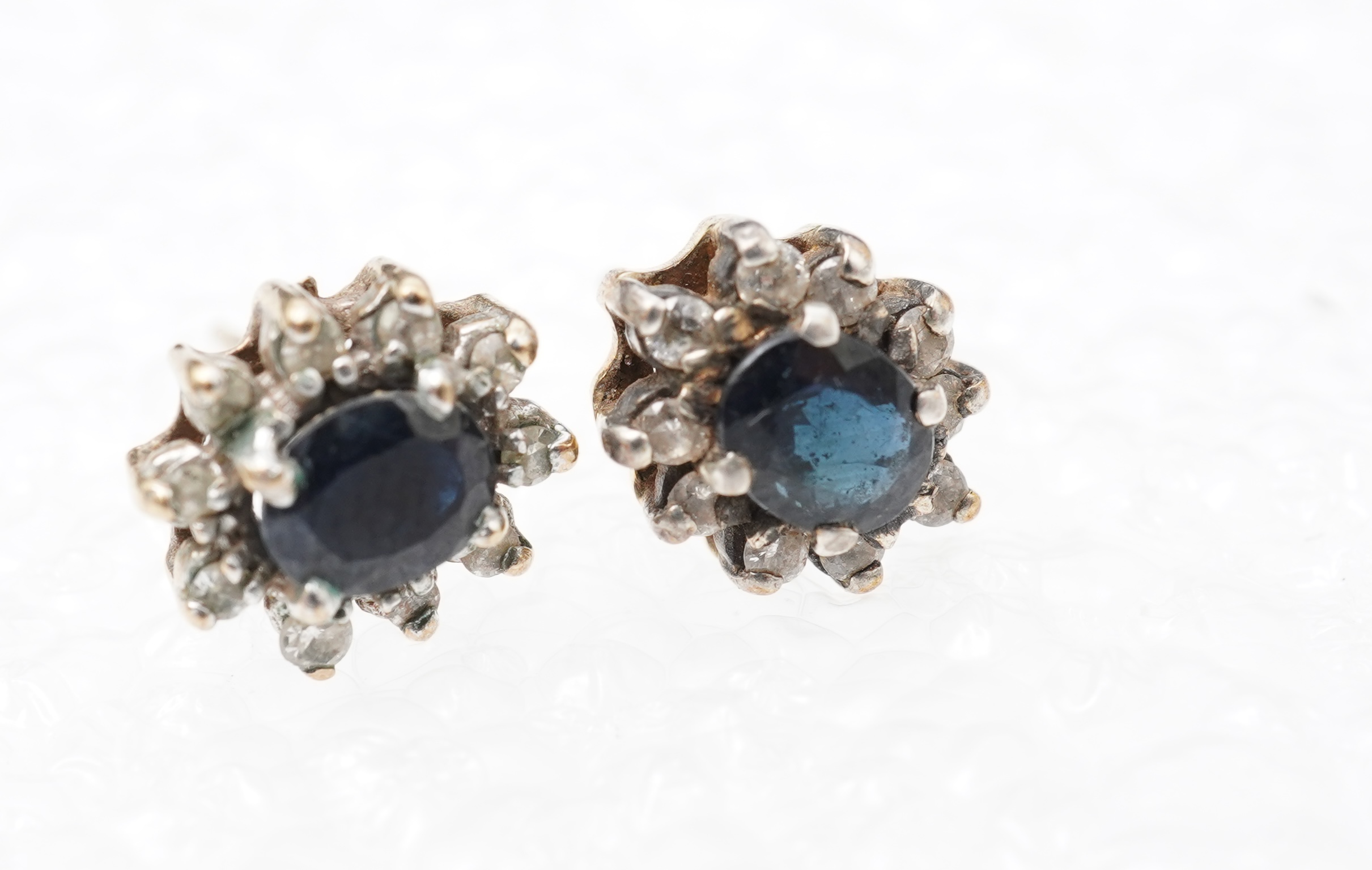 A pair of sapphire and diamond stud earrings, of cluster design, mounted in gold, length 0.9cm each